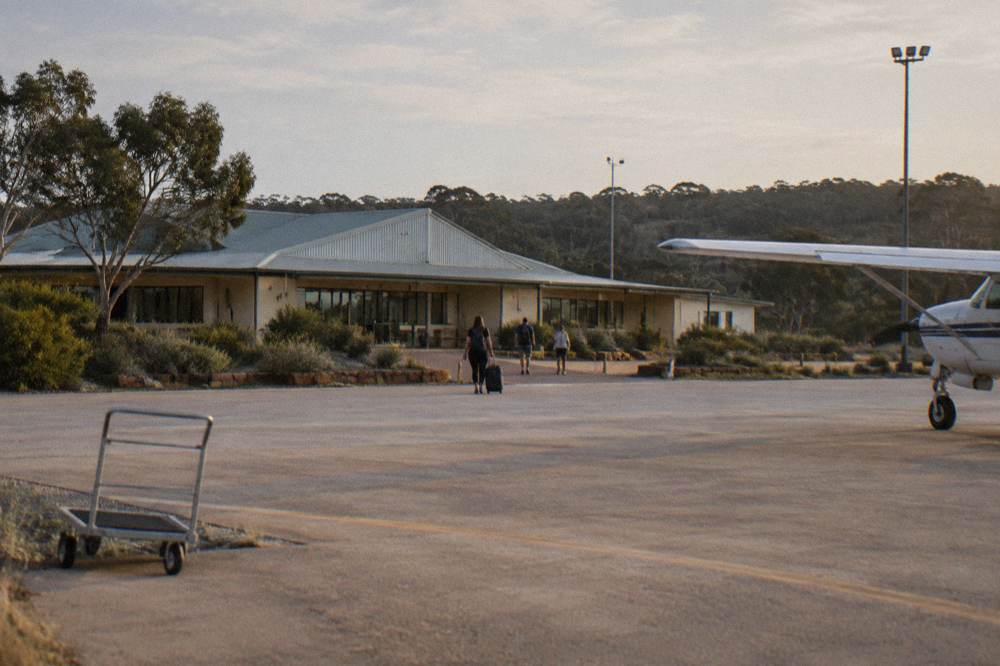 A small regional airport building beside a tarmac and open sky